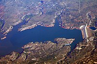 Overhead view of the lake with several bays and the large dam