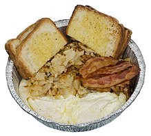 Metal container of hash browns, eggs, bacon, and slices of white bread.