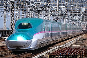 Teal and white bullet train with pink stripe