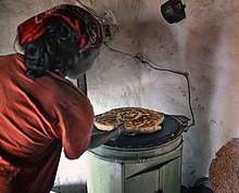 Woman baking bread on an electric stove