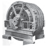 A large traction motor with a circular frame. The external web of a crank drive to the coupling rod is visible.