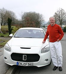 Man standing in front of a white sports car