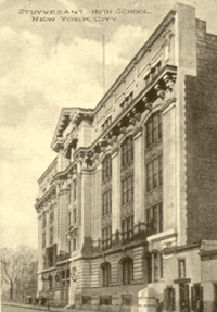 A grayscale postcard showing the Old Stuyvesant Campus in Manhattan's East Village. The postcard's vantage point is from down the street from the old building and depicts the five-story stone facade of the building.