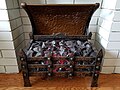 A 1920s coal basket style electric fireplace. The flickering effect is achieved by mounting a fan atop an incandescent bulb, which rotates due to the heat rising from the bulb. This fireplace has been rewired and the original heating element has been removed due to safety concerns.