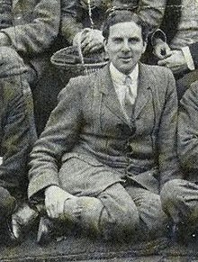 Man in suit seated on the ground