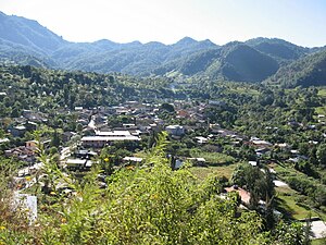 A view overlooking Canelas. The buildings are surrounded by green mountains.