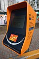 部分车站设有新款香港轻铁入站收费器，此款为橙色，使用LCD显示，同时支持智能车票