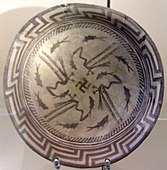 Samarra plate, with an abstract rim, a circle of eight fish, and four birds catching four fish that swim towards a central swastika; circa 4000 BC; painted ceramic; diameter: 27.7 cm; Vorderasiatisches Museum Berlin