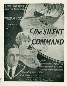 A man in a suit; behind him, a woman wearing jewelry and holding a cigarette holder. Smoke rising from the cigarette appears to become water; in it, a Navy ship is on fire and sinking. Captioned: "Love Intrigue and the High Seas / William Fox presents / The Silent Command / with Edmund Lowe – Alma Tell – Martha Mansfield – Betty Jewel – Florence Martin – Bela Lugosi / 'Wrecked by Womens Wiles' / A J. Gordon Edwards production / Directed by the Man who staged 'Queen of Sheba' / Story by Rufus King"