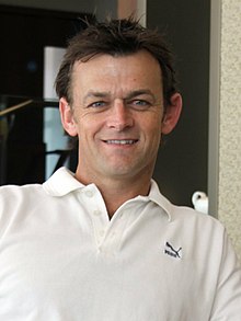 Picture of Gilchrist wearing a white collared T-shirt