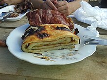 A roll of cooked potato dough known as chochoca, with crispy smoked pork