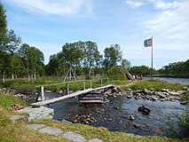 Goahti and flag in Mittådalen by the stream Mittån.