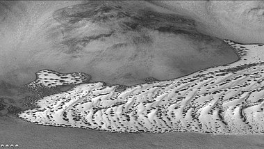 Defrosting dunes in Von Karman Crater, as seen by CTX camera (on Mars Reconnaissance Orbiter). Dark places are where frost has left dark dunes. Picture taken in the springtime on Mars.