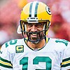 Headshot of Aaron Rodgers in full uniform and helmet smiling