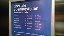 A sign in Dutch, showing opening hours for holidays in December and January. For the dates of 25 December and 1 January, the hours read "gesloten", meaning "closed". The store is open all other days.