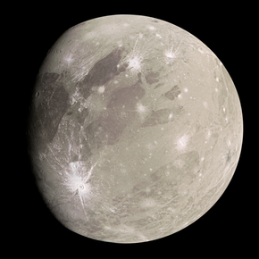 Surface with swatches of light and dark brown. The bright crater on the lower left is the Tros crater.