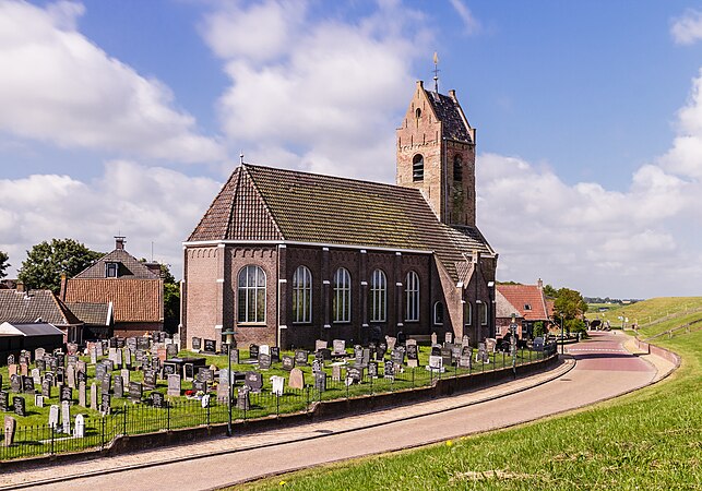 图为从防波堤望向维勒姆村圣母教堂的景观，该村落位于荷兰弗里斯兰省的东北弗里斯兰。