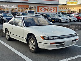 Front view of a two-door car with door mirrors