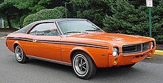 Shows a 1969 AMC Javelin featuring optional in Big Bad Orange paint and optional black vinyl covered roof and full-length bodyside stripes