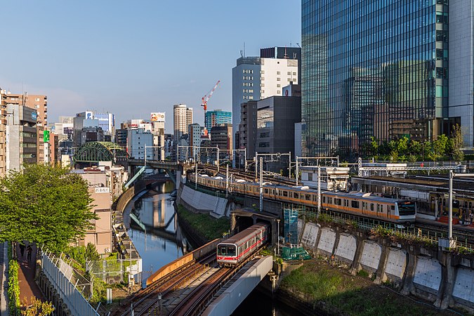 东京地铁的列车正在穿越神田河，而上方的东日本旅客铁道的列车刚刚从御茶之水站驶出。摄于日本东京御茶之水。