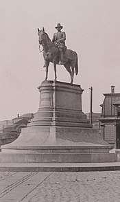 A sepia photograph of a monument consisting of an equestrian statue atop a large pedestal