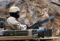 2004年，一位第19特种部队群士兵在阿萨达巴德更换悍马车轮胎时使用M60机枪警戒，旁边可以看到一支AT4火箭筒。
