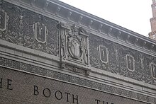 Detail of the facade on 45th Street. The brick section of the facade is surrounded by a stucco band of sgraffito decorations, which is painted beige and contains bas reliefs of classical-style foliate ornamentation.