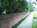 Stone garden wall along sidewalk.