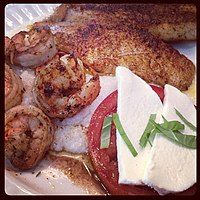 Shrimp and grits along with blackened fish and tomato mozzarella and basil (insalata Caprese)