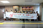 盛冈市政府人员手持左起横书的“谢谢台湾”横幅。