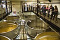 A group of visitors observes fermentation vats whilst in the Black Sheep Brewery.