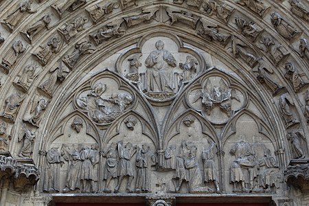 Tympanum of the life of Saint Stephen. The heads of most figures were knocked off during the French Revolution