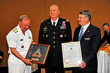 Rear Admiral James (Phil) Wisecup, President of the U.S. Naval War College and Rear Admiral (Ret) Glenn E. Whisler, Jr., Chairman, Naval War College Foundation Board of Trustees, present General Carter, Commander, Multi-National Force-Iraq and Operation Iraqi Freedom with the Naval War College Distinguished Graduate Leadership Award at the Naval Support Activity Washington – Washington Navy Yard Catering and Conference Center. (U.S. Navy photo by Joseph P Cirone/Released).