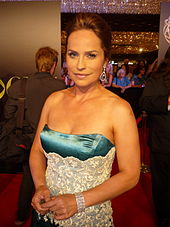 A woman in a blue and white dress looking at the camera.