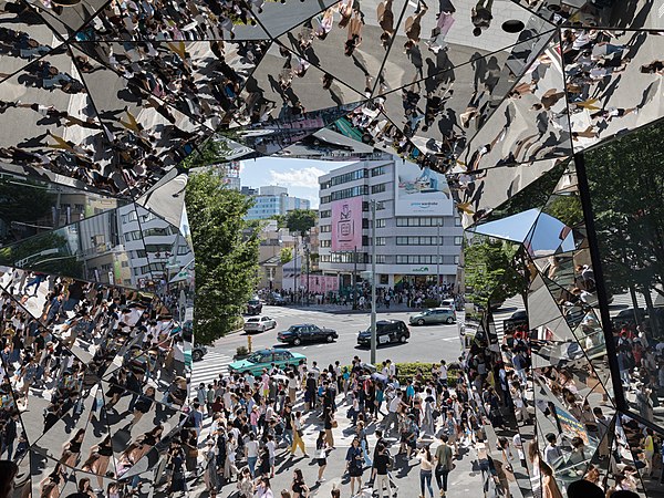 图为于一个阳光明媚的周日下午，在日本东京原宿站东急广场表参道内，镜射著街头人群的多面镜。由建筑师中川博士（Hiroshi Nakamura）设计。
