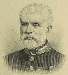 A bearded man in his sixties in military uniform