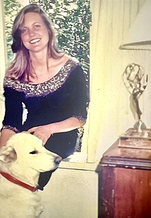 Photo of Lynn Montgomery, with her dog Zuzu and her Emmy award trophy.