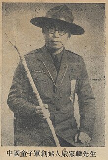 A photo of Yen Chia-lin taken from a newspaper. He is wearing a jacket, a wide brimmed hat, and is holding a stick in his right hand.