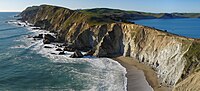 Steep cliffs by a rocky ocean and beach