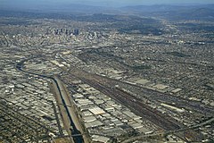 A paved river and railroads lead into downtown Los Angeles.