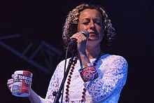 Singer Kate Rusby holding a microphone and a cup of tea