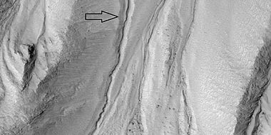 Close view of gully channel, as seen by HiRISE under HiWish program. Arrow shows small channel within larger channel. Small channel is quite curved in this image.