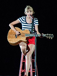 Taylor Swift strumming a guitar