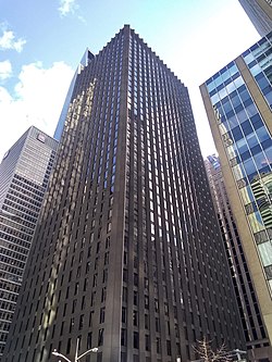 The CBS Building, a skyscraper with a glass-and-black-granite facade, as seen from ground level on a sunny day