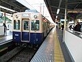 特殊的跨站台换乘形式：在日本阪神电铁尼崎站1号站台与3号站台之间换乘的乘客需要穿过图片中停靠在2号站台的普通列车进行换乘。