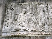 Part of the relief on the Noyon war memorial showing the ruined state of Noyon after the 1914-1918 war. Here a woman sits amidst the ruins