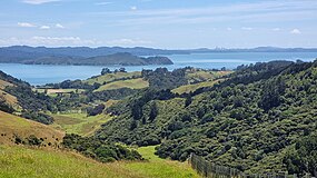 Looking north from Āwhitu Peninsula bush and farmland to the Manukau Harbour and the Auckland CBD
