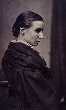 Black and white half-length portrait of Frances Helen Prideaux, a white woman with dark hair pulled back into a bun at the nape of her neck. Prideaux wears a white collar, just showing, and a dark-coloured shawl or dress with voluminous sleeves.