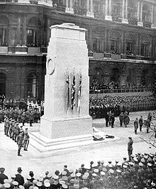 Black and white photograph of a crowd gathered round a monument
