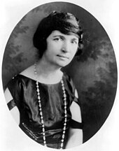 A head/shoulder portrait of an attractive woman, dressed in fashions from around 1920.